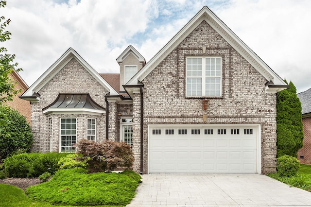 1176 Fairvue Village Ln, Gallatin, TN 37066 - view of front of house with driveway, brick siding, a standing seam roof, and an attached garage