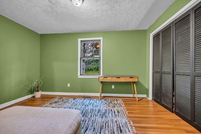 960 Jump Off Rd, Bon Aqua, TN 37025 - bedroom featuring wood finished floors, a closet, and a textured ceiling