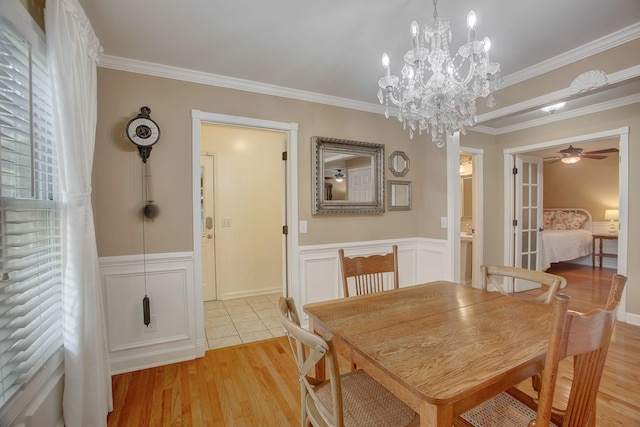 1064 Crane Ct, Kingston Springs, TN 37082 - dining room featuring a ceiling fan, crown molding, a wainscoted wall, light wood-type flooring, and a chandelier