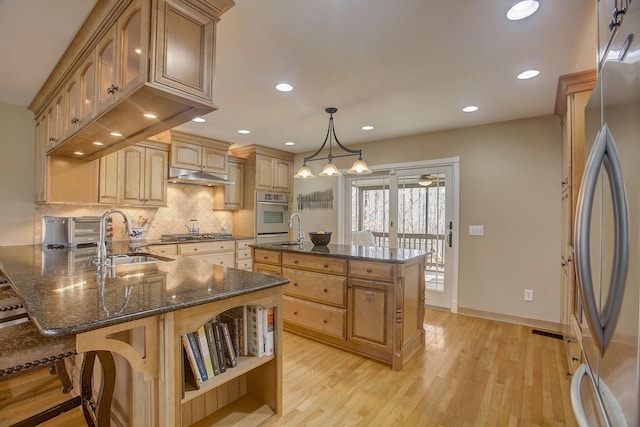 1064 Crane Ct, Kingston Springs, TN 37082 - kitchen featuring appliances with stainless steel finishes, a peninsula, open shelves, decorative backsplash, and light wood finished floors
