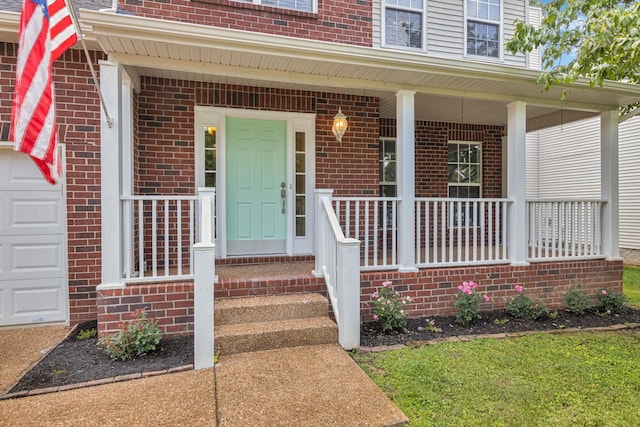 1220 Kelly Ct, Franklin, TN 37064 - view of exterior entry with brick siding, a porch, and an attached garage