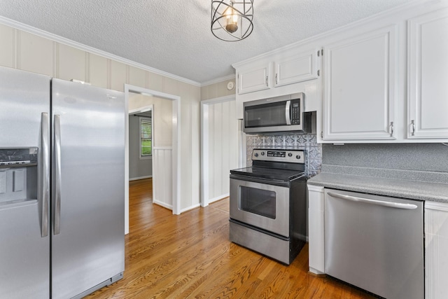 2709 Emery Dr, Nashville, TN 37214 - kitchen featuring stainless steel appliances, crown molding, light wood finished floors, white cabinetry, and light countertops