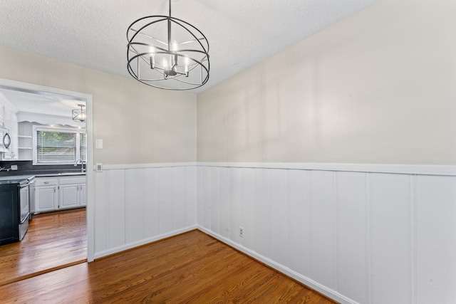 2709 Emery Dr, Nashville, TN 37214 - unfurnished dining area featuring a chandelier, wood finished floors, a textured ceiling, and a wainscoted wall