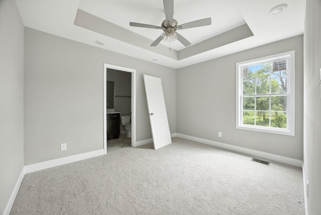 2670 Scott Dr, Clarksville, TN 37042 - unfurnished bedroom featuring carpet flooring, a tray ceiling, connected bathroom, and ceiling fan