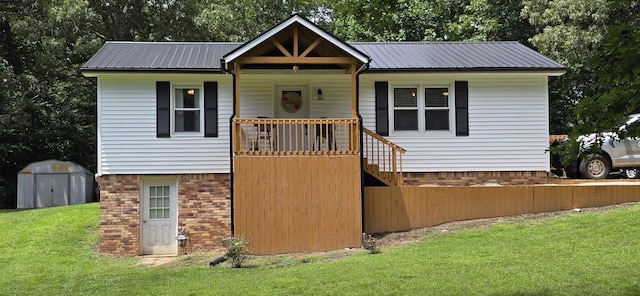 60 Jayson St, Camden, TN 38320 - view of front of home with a shed, a front yard, and a metal roof