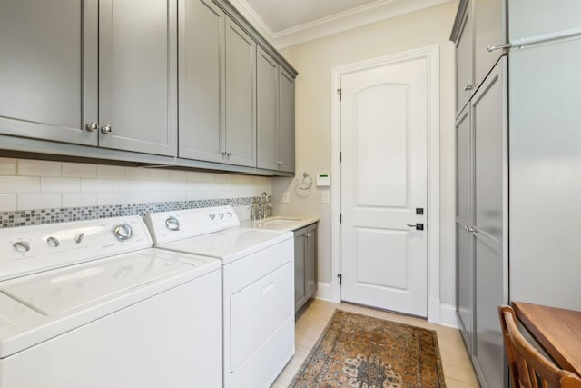 114 Middleton Cir, Nashville, TN 37215 - laundry area featuring cabinet space, ornamental molding, washing machine and clothes dryer, and light wood-style floors