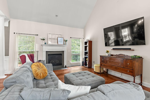 604 Applejack Ct, Antioch, TN 37013 - living area featuring a fireplace with flush hearth, high vaulted ceiling, healthy amount of natural light, wood finished floors, and decorative columns