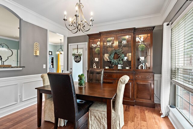 604 Applejack Ct, Antioch, TN 37013 - dining area featuring a chandelier, a wainscoted wall, light wood-style flooring, ornamental molding, and a decorative wall