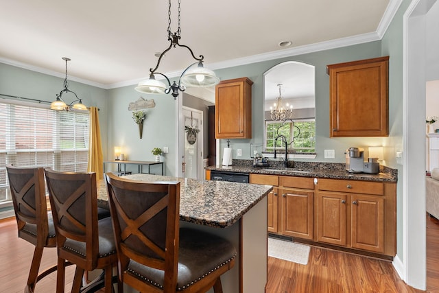604 Applejack Ct, Antioch, TN 37013 - kitchen with a chandelier, light wood-style flooring, a breakfast bar area, brown cabinets, and ornamental molding