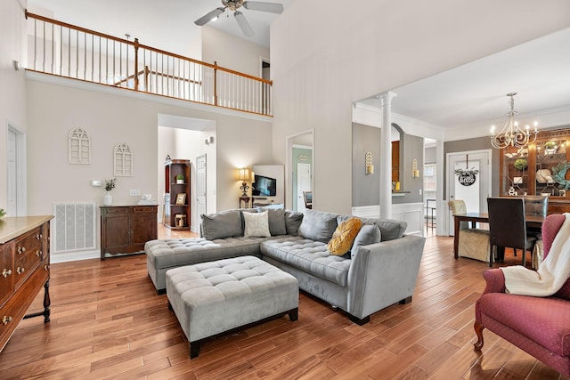604 Applejack Ct, Antioch, TN 37013 - living room featuring a chandelier, light wood-style floors, a ceiling fan, a high ceiling, and wainscoting