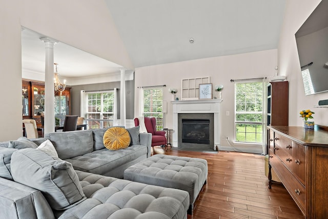 604 Applejack Ct, Antioch, TN 37013 - living area featuring a chandelier, dark wood-style floors, ornate columns, a fireplace with flush hearth, and high vaulted ceiling