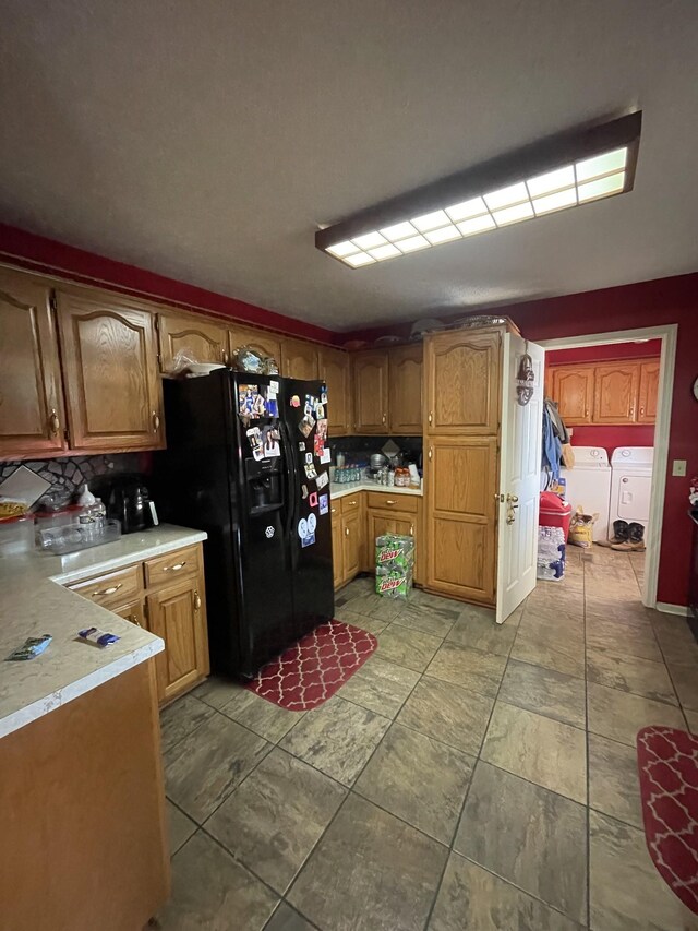 1021 Maple Grove Rd, Lafayette, TN 37083 - kitchen with black refrigerator with ice dispenser, washer and dryer, light countertops, and brown cabinetry