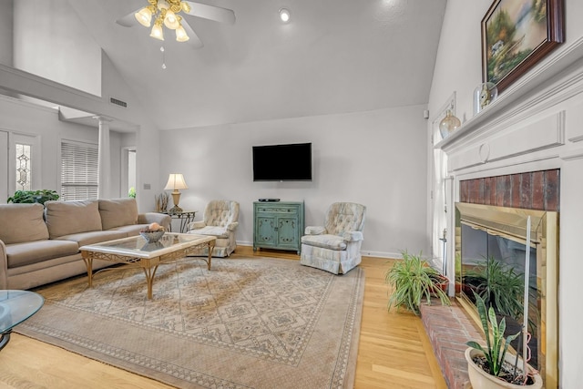 1013 Laurel Hills Dr, Dickson, TN 37055 - living area with high vaulted ceiling, ceiling fan, a brick fireplace, ornate columns, and light wood-type flooring