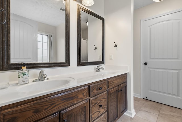 989 Ernest Stewart Dr, Clarksville, TN 37042 - full bathroom featuring double vanity, tile patterned flooring, and a textured ceiling