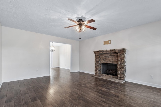 989 Ernest Stewart Dr, Clarksville, TN 37042 - unfurnished living room featuring ceiling fan, a fireplace, dark wood-style flooring, a textured ceiling, and a chandelier