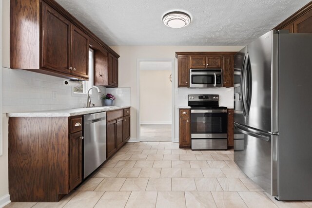 989 Ernest Stewart Dr, Clarksville, TN 37042 - kitchen with appliances with stainless steel finishes, light countertops, backsplash, dark brown cabinets, and a textured ceiling