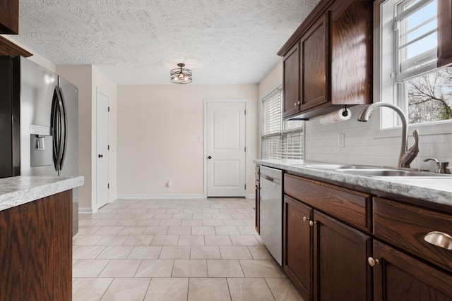 989 Ernest Stewart Dr, Clarksville, TN 37042 - kitchen featuring stainless steel appliances, light countertops, tasteful backsplash, dark brown cabinets, and a textured ceiling