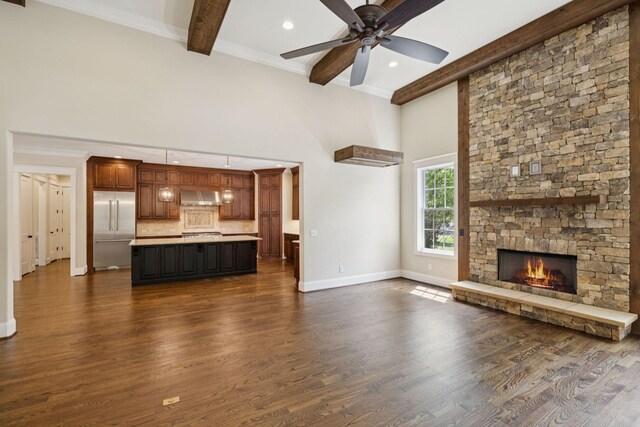 703 Welsh Ln, Franklin, TN 37064 - unfurnished living room featuring beam ceiling, dark wood finished floors, a ceiling fan, a fireplace, and a high ceiling