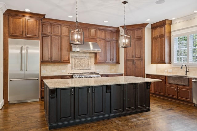 703 Welsh Ln, Franklin, TN 37064 - kitchen featuring appliances with stainless steel finishes, wall chimney exhaust hood, a center island, dark wood-style flooring, and recessed lighting
