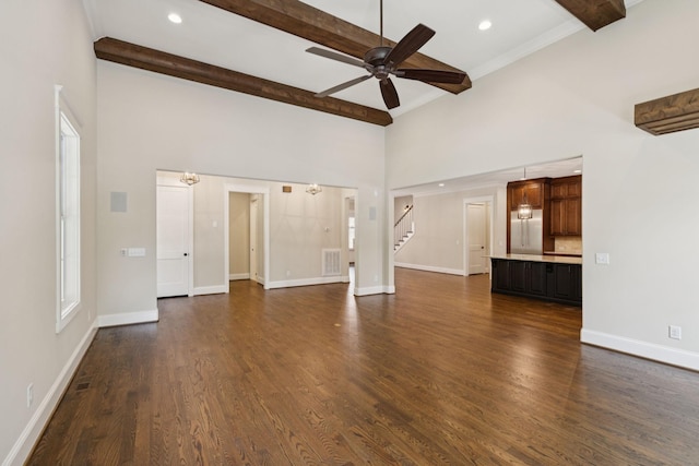 703 Welsh Ln, Franklin, TN 37064 - unfurnished living room with beam ceiling, a towering ceiling, ceiling fan, stairs, and dark wood-style floors
