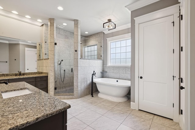 703 Welsh Ln, Franklin, TN 37064 - full bathroom featuring two vanities, a stall shower, a freestanding tub, tile walls, and tile patterned flooring