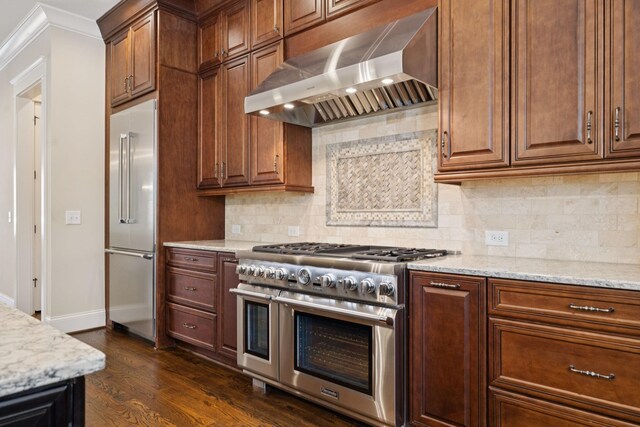 703 Welsh Ln, Franklin, TN 37064 - kitchen with high quality appliances, exhaust hood, dark wood-type flooring, light stone countertops, and ornamental molding