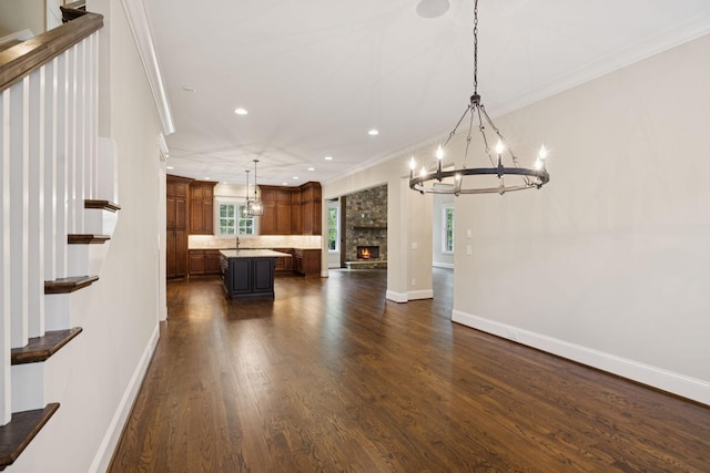 703 Welsh Ln, Franklin, TN 37064 - kitchen with crown molding, a chandelier, open floor plan, a kitchen island, and dark wood-style flooring
