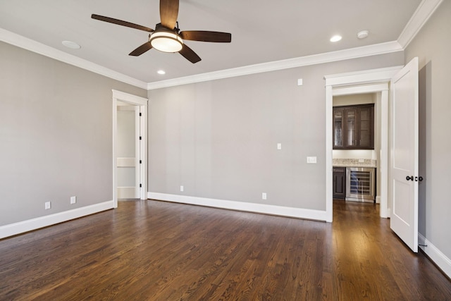 703 Welsh Ln, Franklin, TN 37064 - empty room featuring beverage cooler, ornamental molding, a bar, ceiling fan, and dark wood finished floors