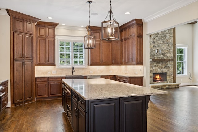 703 Welsh Ln, Franklin, TN 37064 - kitchen featuring a kitchen island, dark wood-style flooring, light stone countertops, tasteful backsplash, and ornamental molding