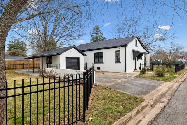 222 Groh St, Lawrenceburg, TN 38464 - view of front facade featuring concrete driveway, stucco siding, a garage, and a fenced front yard