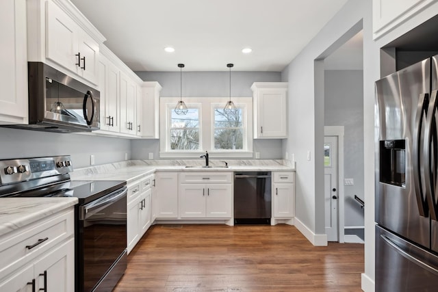 222 Groh St, Lawrenceburg, TN 38464 - kitchen featuring appliances with stainless steel finishes, white cabinets, wood finished floors, decorative light fixtures, and recessed lighting