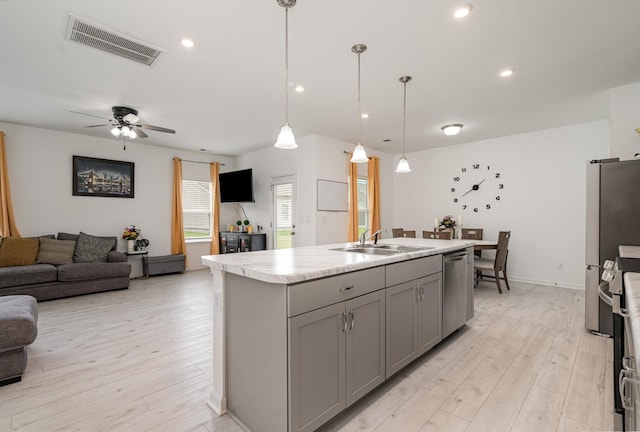 3716 Capstone Dr, Murfreesboro, TN 37128 - kitchen with gray cabinets, stainless steel appliances, open floor plan, light countertops, and light wood-style flooring