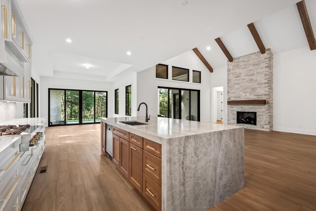 6628 Bethesda Arno Rd, Thompsons Station, TN 37179 - kitchen featuring stainless steel gas cooktop, open floor plan, wood finished floors, light stone countertops, and beamed ceiling