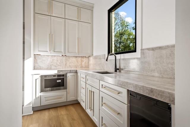 6628 Bethesda Arno Rd, Thompsons Station, TN 37179 - kitchen with light countertops, tasteful backsplash, white cabinetry, and light wood-style flooring