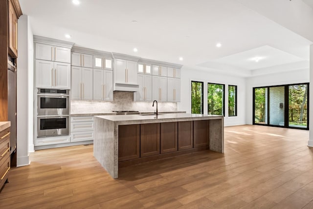 6628 Bethesda Arno Rd, Thompsons Station, TN 37179 - kitchen featuring appliances with stainless steel finishes, recessed lighting, tasteful backsplash, light wood-type flooring, and a raised ceiling