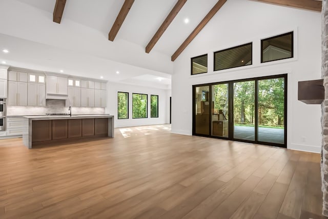 6628 Bethesda Arno Rd, Thompsons Station, TN 37179 - unfurnished living room with high vaulted ceiling, beamed ceiling, light wood-style flooring, recessed lighting, and healthy amount of natural light