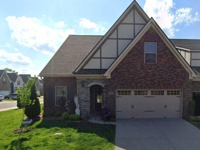 3056 Huntsman Dr, Gallatin, TN 37066 - english style home featuring an attached garage, a front lawn, concrete driveway, brick siding, and roof with shingles