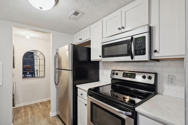 420 Elysian Fields Rd Unit C3, Nashville, TN 37211 - kitchen featuring stainless steel appliances, light countertops, light wood finished floors, white cabinets, and tasteful backsplash