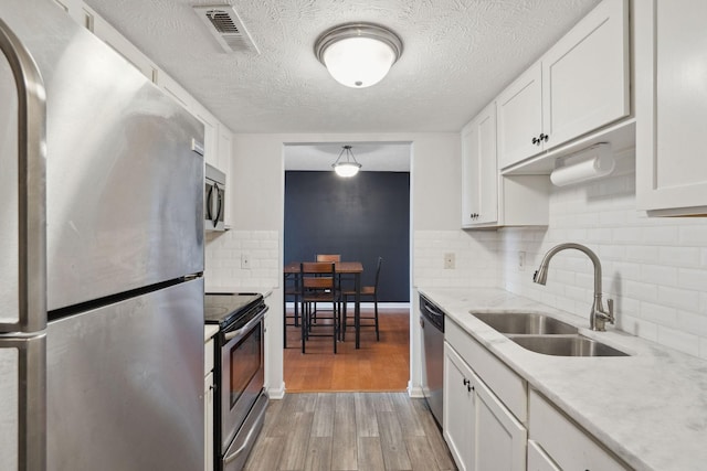 420 Elysian Fields Rd Unit C3, Nashville, TN 37211 - kitchen with stainless steel appliances, light countertops, light wood-type flooring, white cabinets, and a textured ceiling
