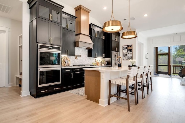 5762 Willoughby Way, Murfreesboro, TN 37129 - kitchen featuring stainless steel appliances, light wood-type flooring, backsplash, light countertops, and dark cabinets