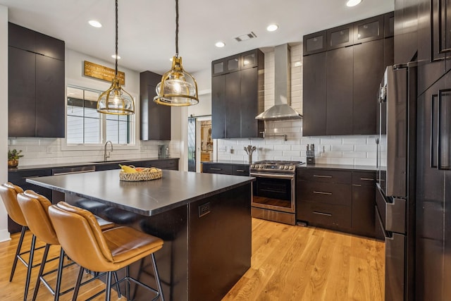 4080 Coles Ferry Pike, Lebanon, TN 37087 - kitchen featuring appliances with stainless steel finishes, wall chimney exhaust hood, dark countertops, light wood-type flooring, and recessed lighting