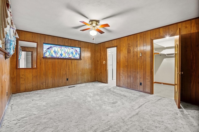 3841 Rollingwood Dr, Chattanooga, TN 37406 - unfurnished bedroom featuring carpet, wood walls, a walk in closet, ceiling fan, and a closet