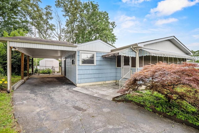 3841 Rollingwood Dr, Chattanooga, TN 37406 - view of front facade with entry steps, driveway, a storage unit, and an attached carport