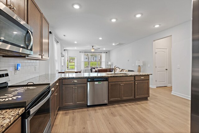 832 Green Meadow Ln, Smyrna, TN 37167 - kitchen featuring stainless steel appliances, light wood finished floors, a ceiling fan, dark brown cabinets, and decorative backsplash