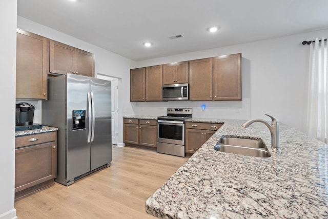 832 Green Meadow Ln, Smyrna, TN 37167 - kitchen featuring stainless steel appliances, light wood-style floors, decorative backsplash, recessed lighting, and light stone countertops
