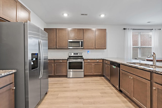 832 Green Meadow Ln, Smyrna, TN 37167 - kitchen with stainless steel appliances, light wood-type flooring, light stone countertops, decorative backsplash, and recessed lighting