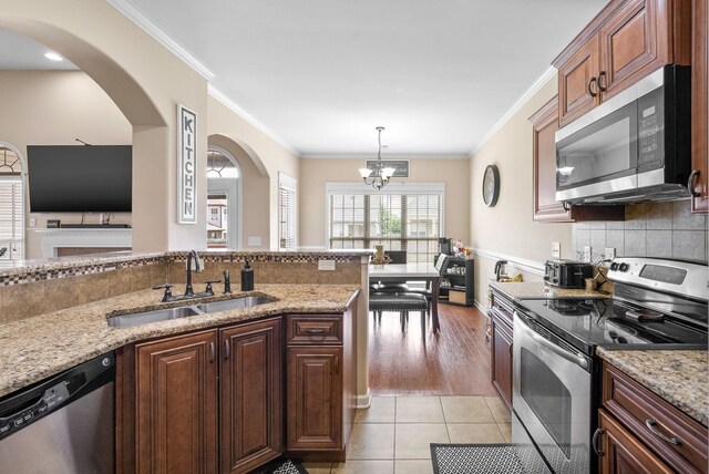 3351 Cotham Ln, Clarksville, TN 37042 - kitchen with stainless steel appliances, arched walkways, a chandelier, tasteful backsplash, and light stone countertops