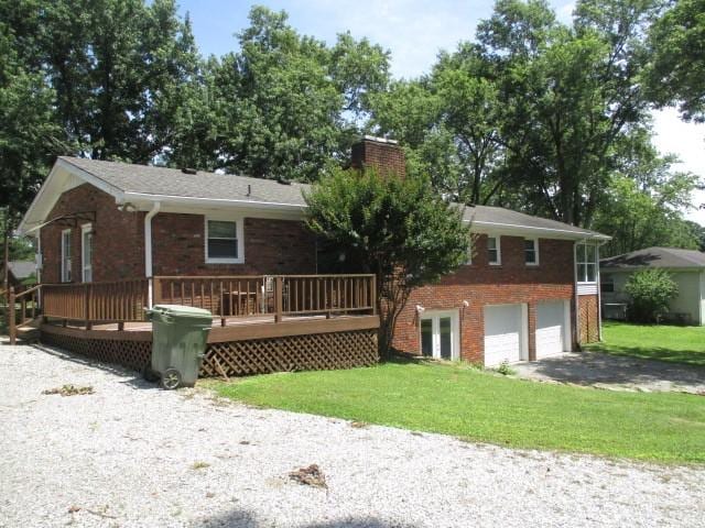 829 Kenny St, Gallatin, TN 37066 - view of front facade with brick siding, a chimney, a garage, asphalt driveway, and a front lawn