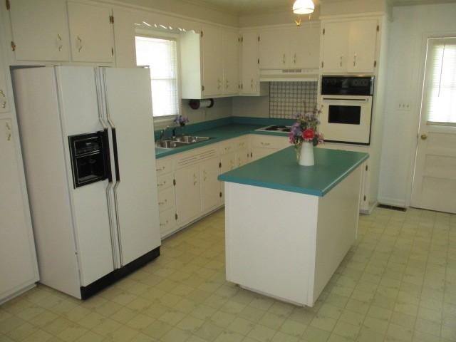 829 Kenny St, Gallatin, TN 37066 - kitchen with white appliances, white cabinets, custom exhaust hood, and a center island