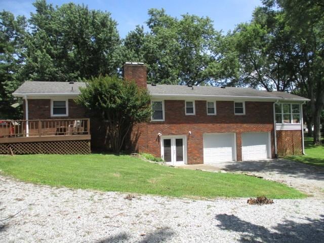 829 Kenny St, Gallatin, TN 37066 - rear view of property with a chimney, a garage, gravel driveway, brick siding, and french doors